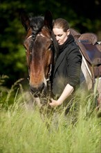 Woman with a Belgian Draft Horse in a meadow