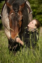 Woman with a Belgian Draft horse in a meadow