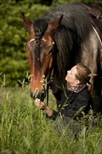 Woman and a Belgian Draft horse in a meadow