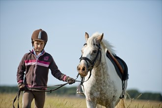 Girl leading a pony on the reins