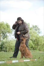 Woman longeing a mixed-breed dog