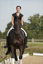 Woman riding a Holsteiner horse