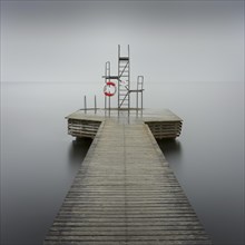 Wooden jetty with diving platform and lifebelt at lake Sommen