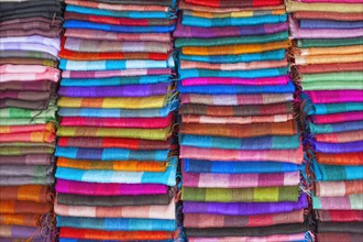 Colourful silk textiles on display at a market stall in Luang Prabang