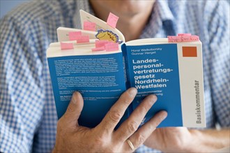 Man reading the book 'Landespersonalvertretungsgesetz'