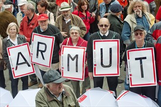 Senior citizens holding protest posters spelling out the word 'Armut'