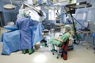 Anaesthetist monitoring a spinal surgery with a neurosurgeon in an operating room