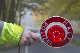 Policeman holding a signalling disc