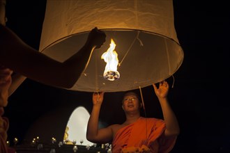 Monks releasing a Kongming lantern or sky lantern for luck during the Loi Krathong or Loy Gratong Festival
