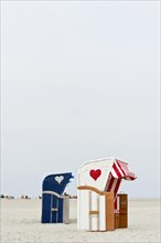 Roofed wicker beach chairs with hearts