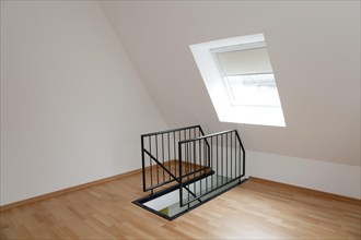 Empty room in the top floor with a staircase railing
