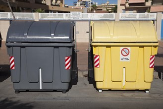 Wheeled trash cans for residual waste and recycling material standing on the roadside