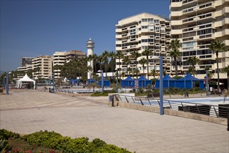 Beach promenade with high-rise buildings and a lighthouse