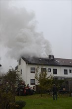 Thick smoke escaping from the roof during a roof fire