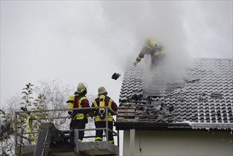 Firefighters wearing breathing equipment while extinguishing a roof fire