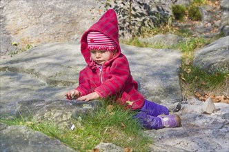 Little girl playing between rocks in the sand
