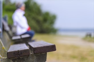 A woman sitting on a bench on the Baltic coast