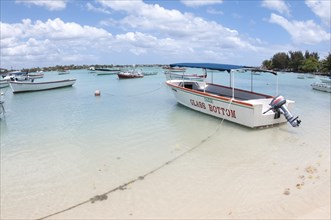 Glass bottom tourist boat moored beside sandy beach