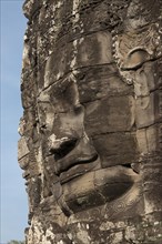 Large sculpture of head on tower of Khmer temple