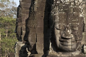 Large sculptures of heads on tower of Khmer temple
