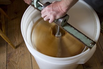 Honeycomb frames are placed into a spinning drum and then spun at high speed to separate the honey from the comb