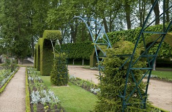 Topiary archways over metal framework in public park garden