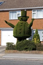 Topiary man in house front garden