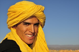 Young man wearing a yellow Moroccan shesh or Touareg turban