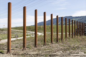 Rusty steel poles for flood protection at the hydroelectric power plant in Malters