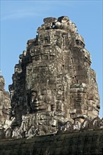 View towards one of the more than 50 mystical towers of Bayon Temple with huge carved stone faces