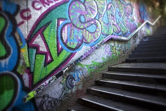 A dark staircase with graffiti