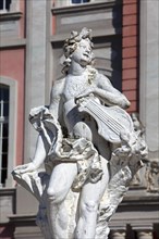 Baroque statue holding a musical instrument in front of the Electoral Palace in Trier