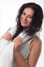 Smiling young woman with a towel around her neck after fitness training
