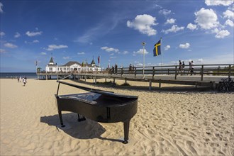 Pier with a grand piano on a beach