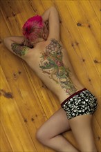 Woman with tattoos on arm and back