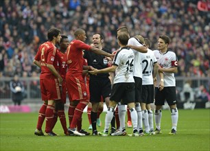 Mass confrontation of players from FC Bayern and Eintracht Frankfurt discussing a decision with referee Marco Fritz