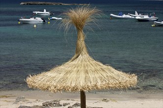 Straw parasol on the beach of Platja Es Trenc