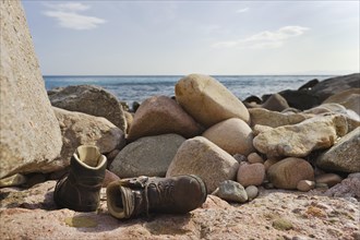 Hiking shoes lying on the beach of Mari Pintau