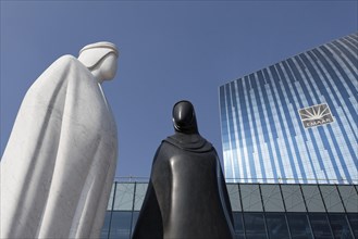 Sculpture of an Arab man and an Arab woman in front of the EMAAR building