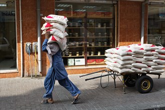 Worker carrying sacks of lentils on his shoulder