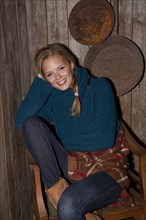 Smiling young woman with a blanket in a hiking hut