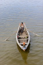 Man in a traditional rowing boat on the Taungthaman Lake