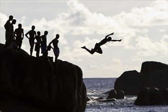 Creole teenagers jumping from rocks