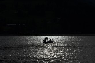 Anglers with backlighting on Weissensee lake