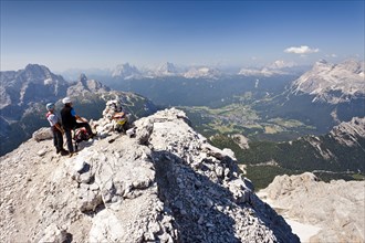 Mountain climbers on the summit of Cristallo di Mezzo Mountain after climbing the Via Ferrata Marino Bianchi climbing route on Mount Cristallo above Cortina