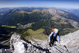 Mountaineers while climbing the Via Ferrata Bolver-Lugli climbing route on Cima Vezzena Mountain in the Pala Group