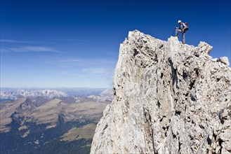 Mountain climber on the summit of Cima Vezzena Mountain in the Pala Group above San Martino