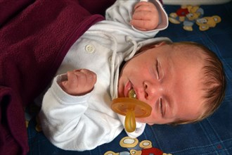 Two-month-old baby sleeping with pacifier
