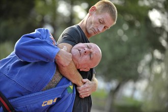 Two men doing martial arts in a park