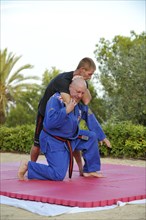 Two men doing martial arts training in a park